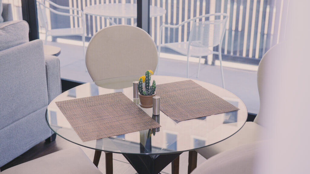 A glass dining table designed for two chairs in a fully furnished apartment